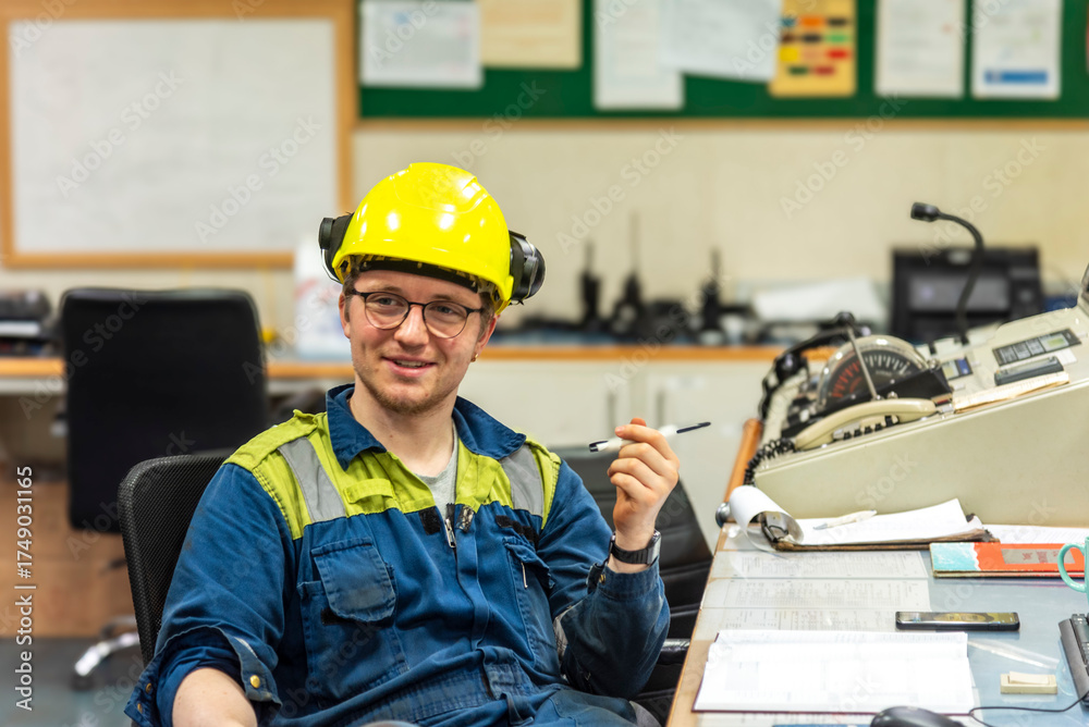 Young marine engineer during his daily routine work in engine room ...