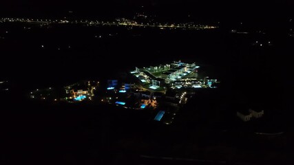 Wall Mural - Panoramic drone shot circling upscale hilltop, holiday villas, night in Greece