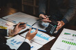 © crizzystudio - Business people analysing financial data using calculator