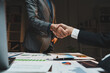 © crizzystudio - Business partners shaking hands confirming a successful deal