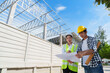 © crizzystudio - Construction engineers discussing building plans at site