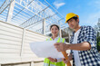 © crizzystudio - Architects or engineers discussing construction plans at building site