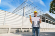© crizzystudio - Young asian engineer holding plans at construction site