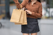 © crizzystudio - Woman carrying shopping bags using mobile phone