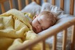 © Pacharee - Sleeping baby covered with yellow blanket in crib.
