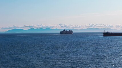 Wall Mural - An aerial drone shot of a cruise ship under a clear blue sky on the beautiful seas of West Vancouver with the mountains of Vancouver Island over the horizon.