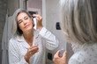 © Westend61 - Applying anti-wrinkle serum during morning skincare routine in bathroom