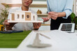 © itchaznong - ESG and Sustainable Design. Team presenting architectural model with focus on eco-friendly features.
