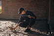 © standret - Sitting and using leveling tool. Builder is working on construction site, unfinished building