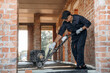 © standret - Process of leveling the concrete on the floor. Builder is working on construction site, unfinished building