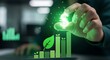 © Shayful Islam GFX - Closeup of a hand placing a glowing dollar sign above a bar graph with a leaf, symbolizing sustainable investment, green finance, and the growth of environmentally friendly business
