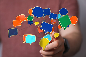 Person touching network of speech bubbles. Represents communication, connection, social media, digital interaction and modern technology.