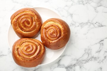 Wall Mural - Tasty roll buns on white marble table, top view. Space for text