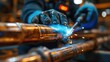 © Elena - A plumber's hand welding copper pipes with a welding torch. Sparks fly as the metal joints are fused together. The scene is set in a workshop environment.