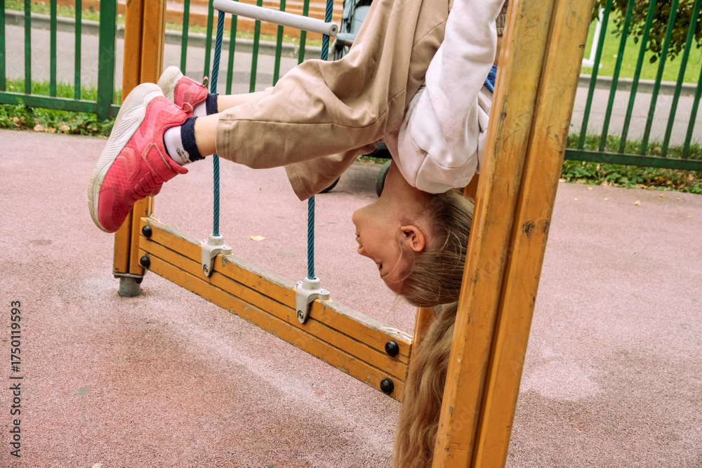 Child Hanging Upside Down on Playground Structure Stock Photo | Adobe Stock