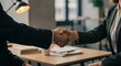 © Nurul - A close-up shot of a professional handshake between a man and a woman in business suits across a desk. This image symbolizes agreement, partnership, signing a deal, merger and acquisition