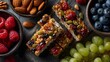 © horizon - Vibrant flat lay of healthy snacks including bowls of fresh almonds, walnuts, berries, and homemade granola bars drizzled with honey and grapes.