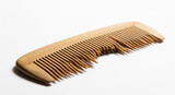 Wooden comb on a white background, with some broken teeth, showcasing natural bamboo and clean beauty accessories in a minimalist, brightly lit studio shot.