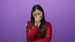 © Krakenimages.com - Woman laughing wearing red jacket with hand over mouth against isolated purple background showing cheerful emotion attractive fashion.