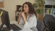 © Krakenimages.com - Young hispanic woman in white blouse at computer monitor with clasped hands to lips in building interior; concern.