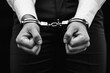 © FARISTABINTA - Dramatic black and white image of man in handcuffs symbolizing arrest or crime