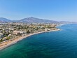 © keBu.Medien - aerial view of the coast with beach and promenade with palms in San Pedro de Alcántara in beautiful light, Malaga, Costa del Sol, Andalusia, Spain