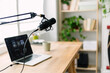© Xavier Lorenzo - Modern podcast recording setup with microphone and laptop on desk in home studio. Creative workspace for digital media production and online broadcasting concept.