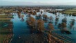 © Irfan Haris - Flooded landscape shows trees standing in still, reflected waters under a cloudy sky
