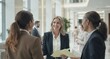 © Julius - Businesspeople in modern lobby, interacting and smiling
