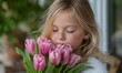 © simba kim - A young girl with blonde hair, highlighted with delicate glitter, is captured in a moment of pure bliss as she brings a vibrant bouquet of pink tulips to her face