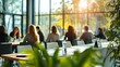 © sambath - People sitting at a conference table with a green plant in the foreground.