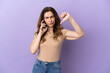 © luismolinero - Middle aged caucasian woman using mobile phone isolated on purple background showing thumb down with negative expression