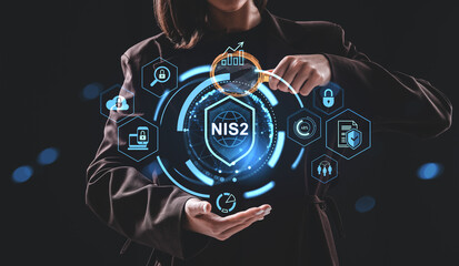 Businesswoman interacting with NIS2 cybersecurity regulation hologram interface concept on dark background using futuristic digital elements..