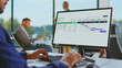 © Videophilia - Business professional using a desktop computer to manage a project schedule and planning tasks with an organized gantt chart application in a modern office environment