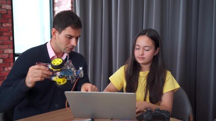 Girl coding robot simulation with teacher guiding her.