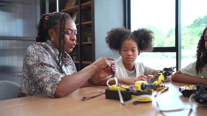 Group of student  coding robot simulation with teacher guiding her.