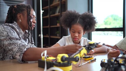 Group of student  coding robot simulation with teacher guiding her.