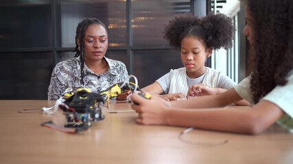 Group of student  coding robot simulation with teacher guiding her.