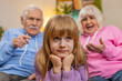 © Andrii Iemelianenko - Irritated angry grandfather and grandmother scolding granddaughter for bad behavior and disobedience on sofa, raising voice scream at little grandchild. Difficulties of upbringing, misbehaved child