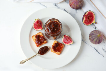 Canvas Print - Plate with jar of sweet fig jam and tasty toasts on marble background