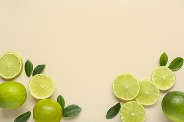 Wall Mural - Fresh ripe limes and leaves on beige background