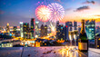 © ECLIPTICFRAMES - Colorful New Year's fireworks explode over the city, a beautiful evening display of light and reflections to celebrate the holiday.