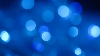 Wall Mural - Blue Bokeh Light Abstract Background - An abstract background featuring soft, blurred blue bokeh lights. The video is filled with various sized circles of light, creating a dreamy, elegant effect.