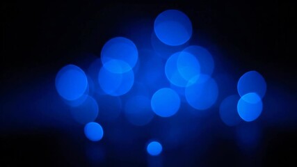 Wall Mural - Blue Bokeh Light Abstract Overlay - An video featuring a collection of blurry, circular blue bokeh lights against a dark background.