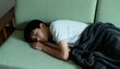© Ksenia - sleep-deprived asian teen on couch under overcast light, fatigued moody vibe, limp posture, top-down