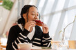 © Maria Vitkovska - Young African American woman enjoying sweet raspberry pastry in cafe, food concept