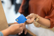 © fizkes - Retail store customer giving blue plastic credit card to cashier