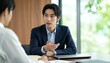© Yka - 若い男性に熱心に説明するビジネスマン