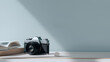 © Zen - Vintage camera and open book on a table against a light blue wall