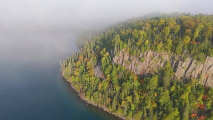 Wall Mural - Vertical cliff and forest during early autumn at Lake Superior shoreline in Ontario, Canada.